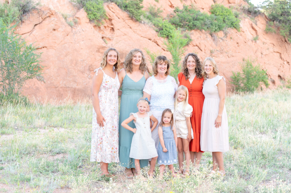 Family standing in a meadow in Red Rock Canyon Open Space, one of Colorado Springs family photos best locations
