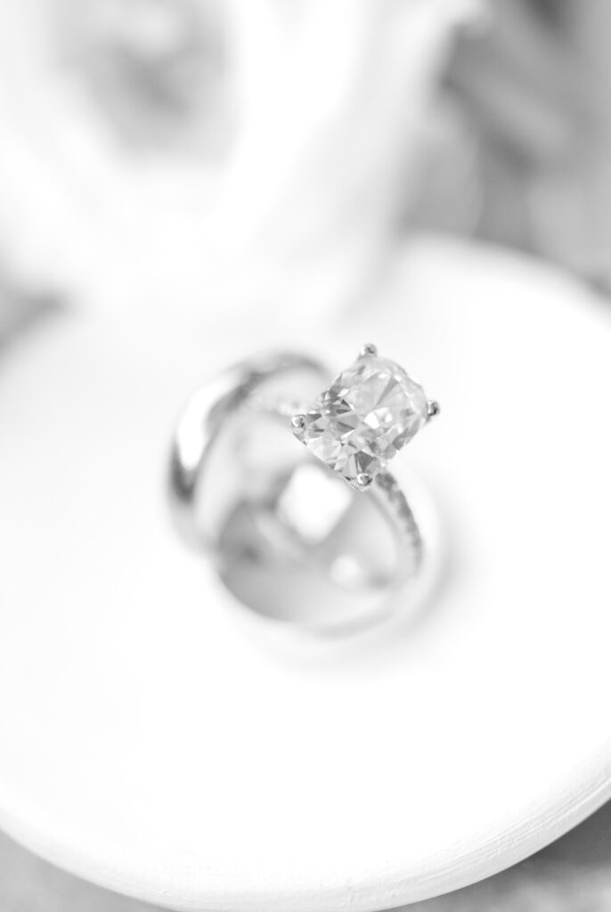 black and white detail photo of bride's ring sitting inside the groom's ring