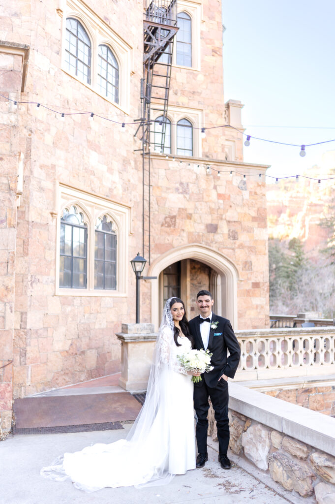 Bride and groom standing on the castle grounds at Glen Eyrie Castle in Colorado Springs