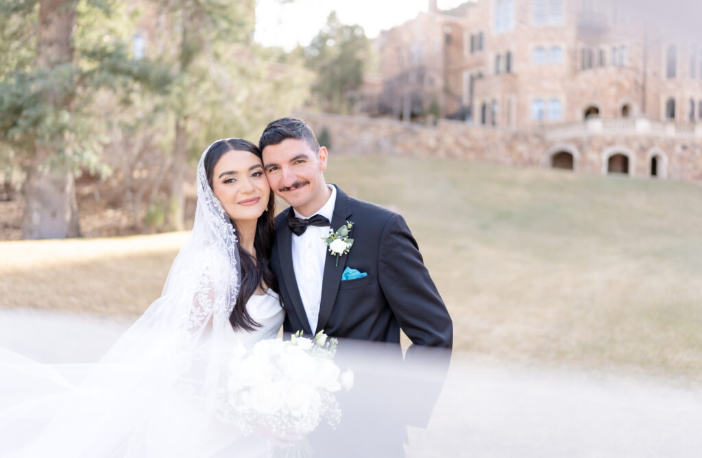Bride and groom leaning their heads together to smile towards the camera on their elopement day at glen eyrie castle 