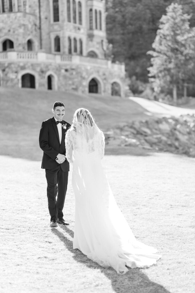 Groom turning around and smiling at his bride during their first look together at glen eyrie castle 