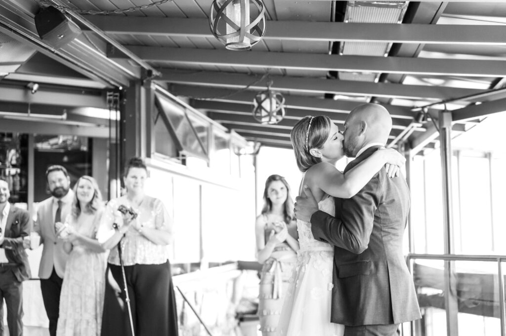 Bride and groom exchange a kiss during their dance at their wedding reception
