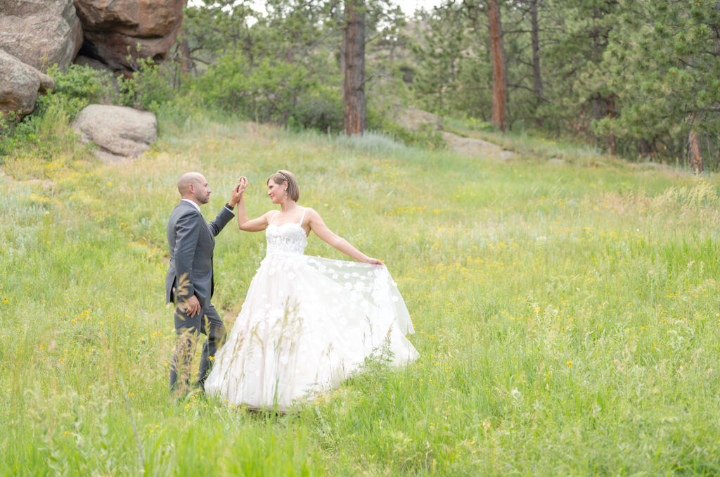 Newly married couple dancing together in a field of wildflowers near Flagstaff House Boulder during their summer wedding in Colorado