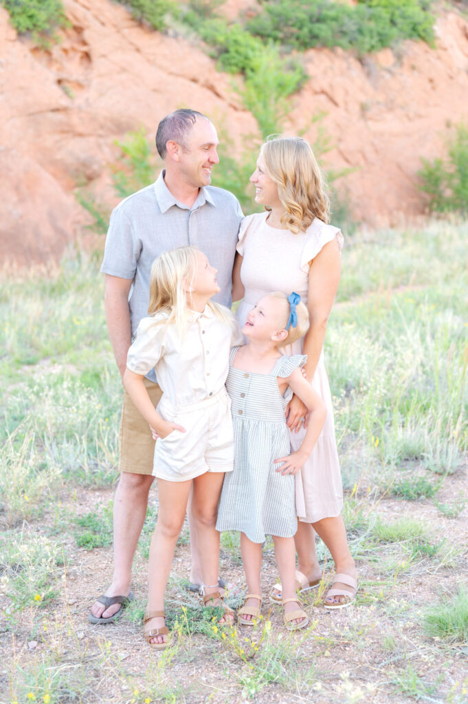 Children smiling up at their parents as mom and dad gaze at each other