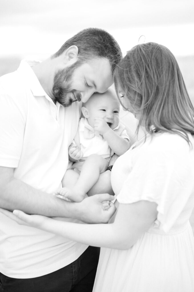 Young couple snuggle their daughter during a photoshoot with a Colorado Springs family photographer