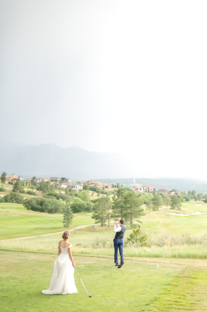 Bride and groom playing golf together in the wedding clothes during their just-married portraits after their wedding ceremony at the Flying Horse Resort in Colorado