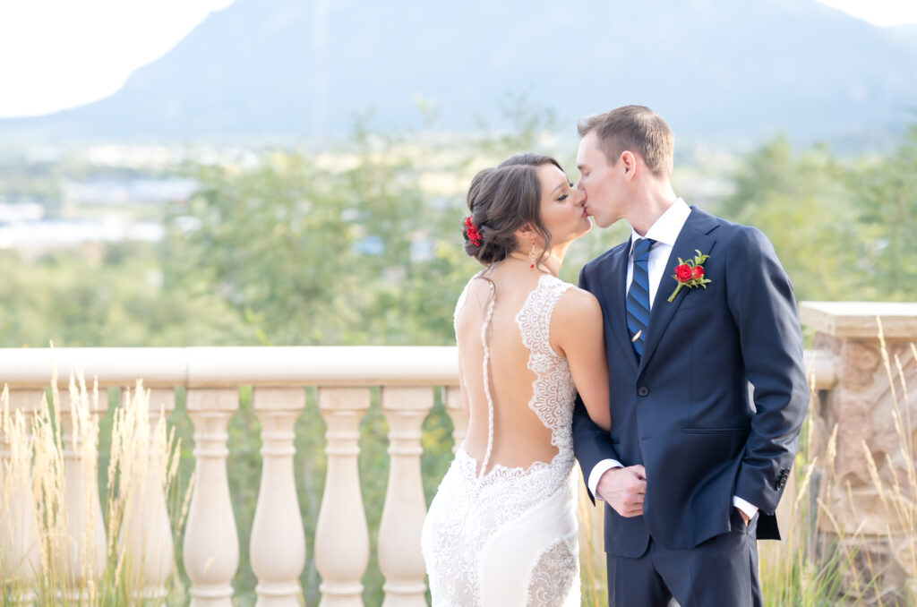 Bride and groom sharing a kiss at The Pinery At The Hill with mountain views behind them 