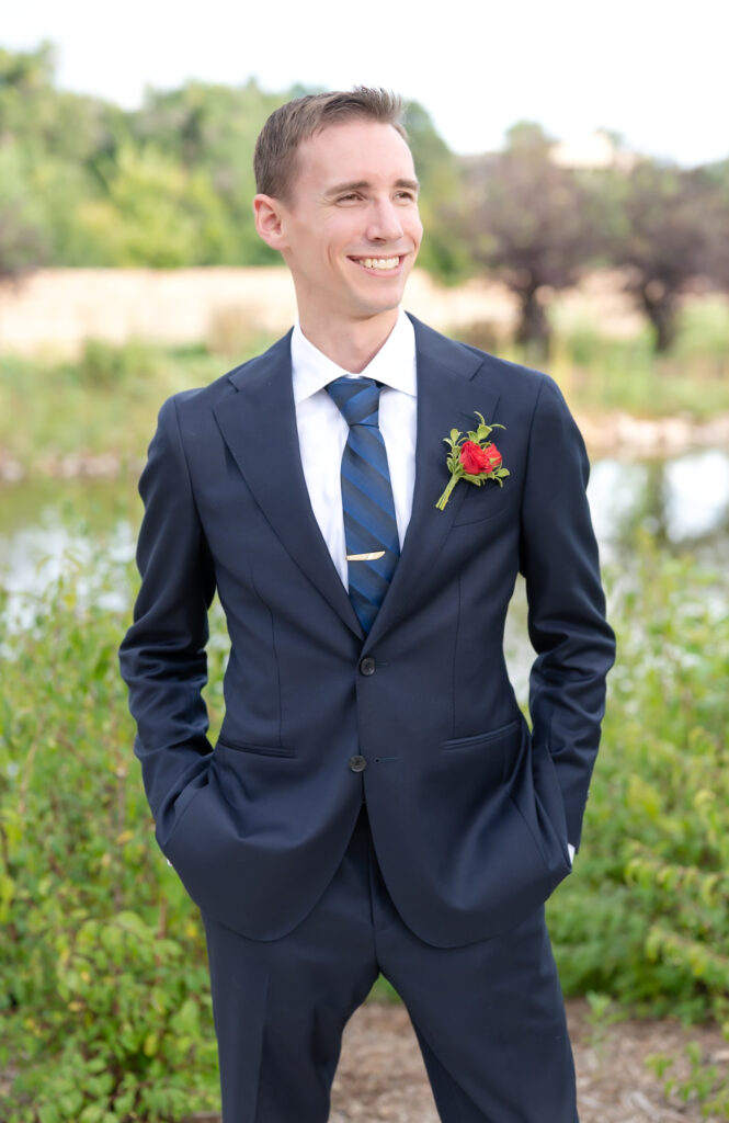 groom smiling with his hands in his pockets on his Colorado wedding day at Pinery at the Hill