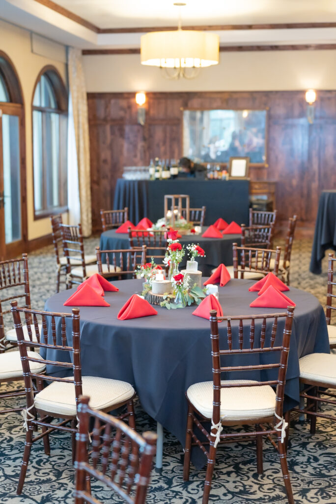 Reception tables decorated with red and black romantic wedding details at The Pinery at The Hill wedding venue in Colorado