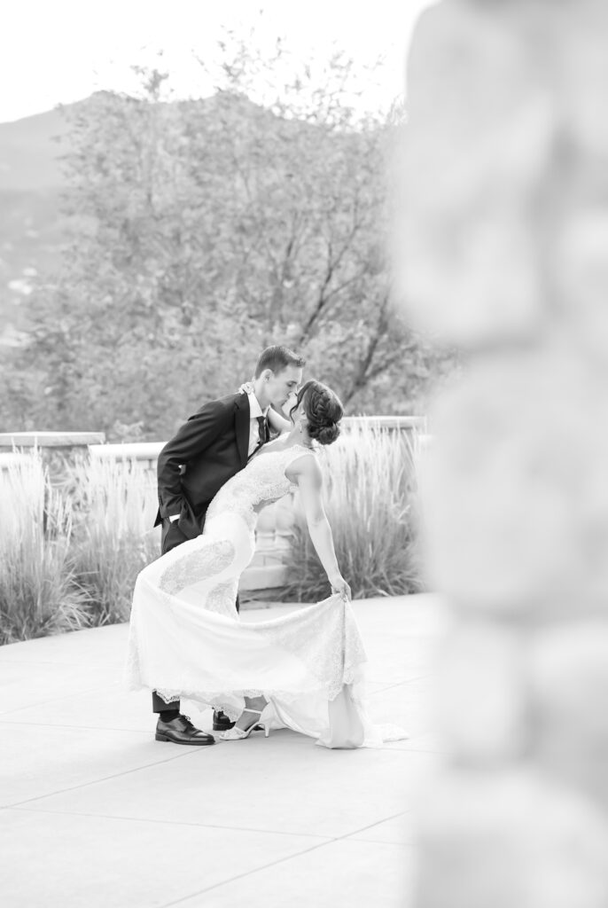 Groom dipping his bride back for a kiss at The Pinery at The Hill venue in Colorado Springs