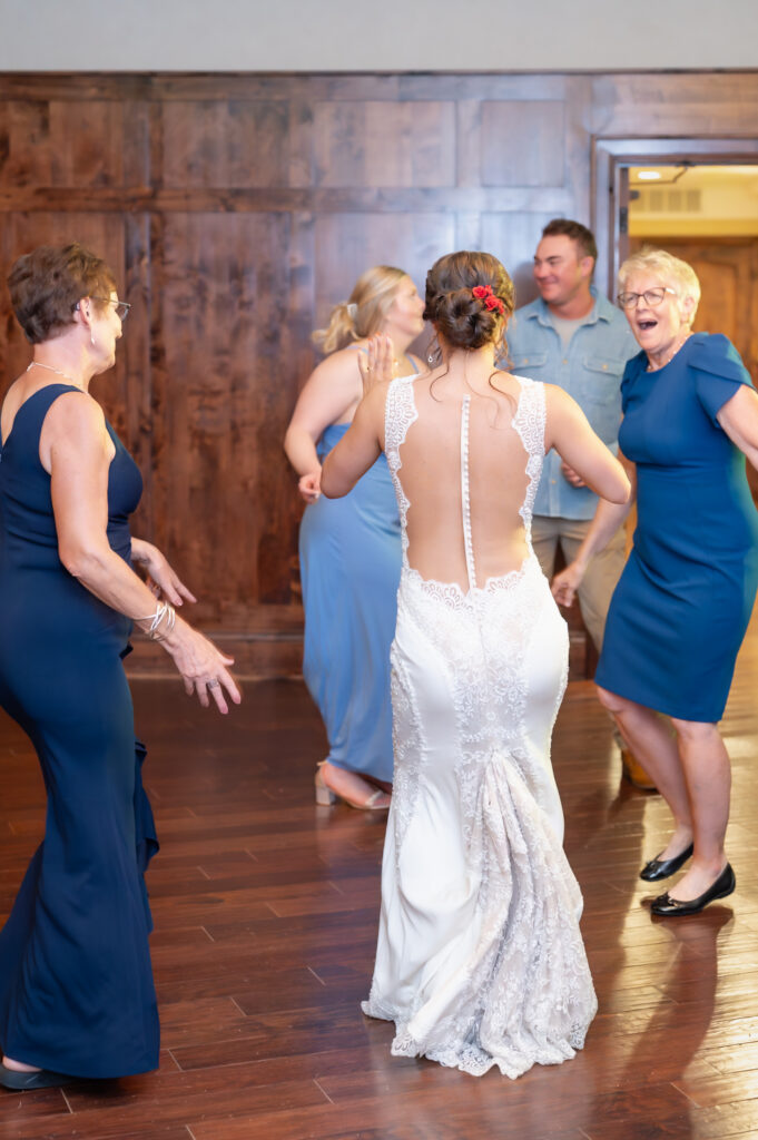 Guests dancing on the reception dance floor with the bride at The Pinery At The Hill wedding venue