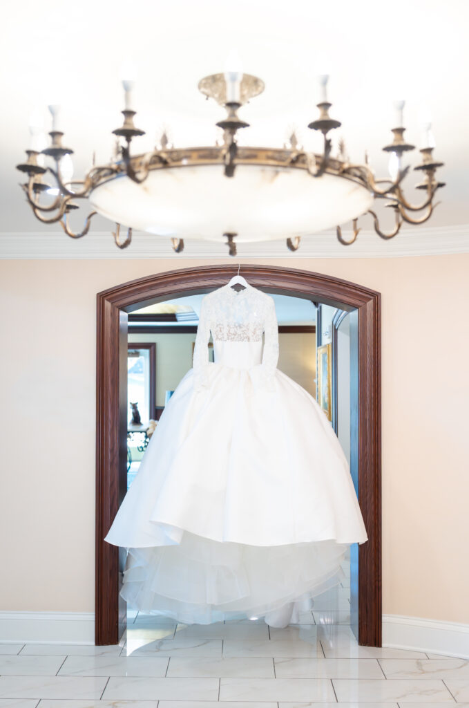 Winter wedding dress hanging in the bridal suite at The Broadmoor wedding venue in Colorado Springs, captured by a Colorado Springs wedding photographer