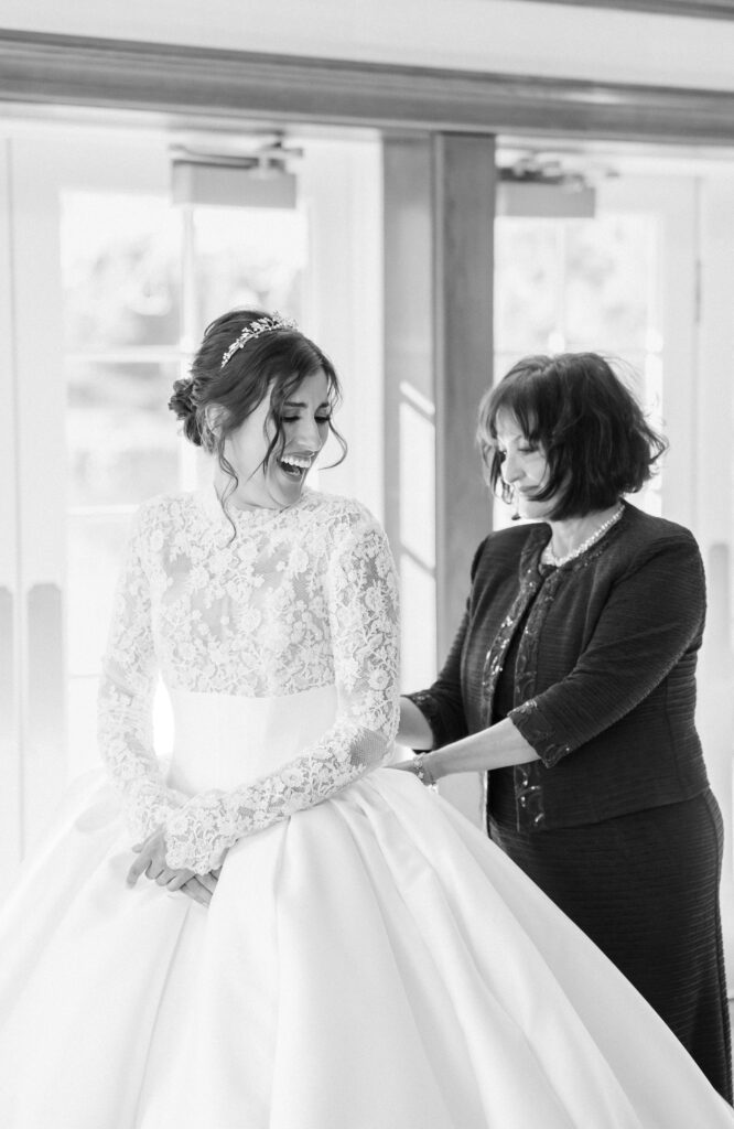 Mother of the bride helping zip up the back of the bride's wedding dress at The Broadmoor