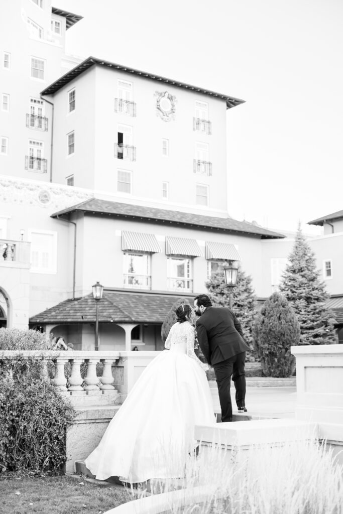 Groom turning back to give his bride a kiss at The Broadmoor, for their winter wedding, in Colorado Springs