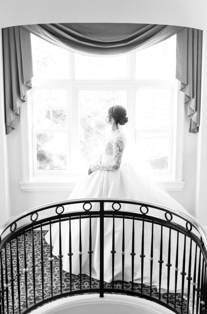 Black and white editorial portrait of the bride looking out the window on her colorado springs wedding day at The Broadmoor