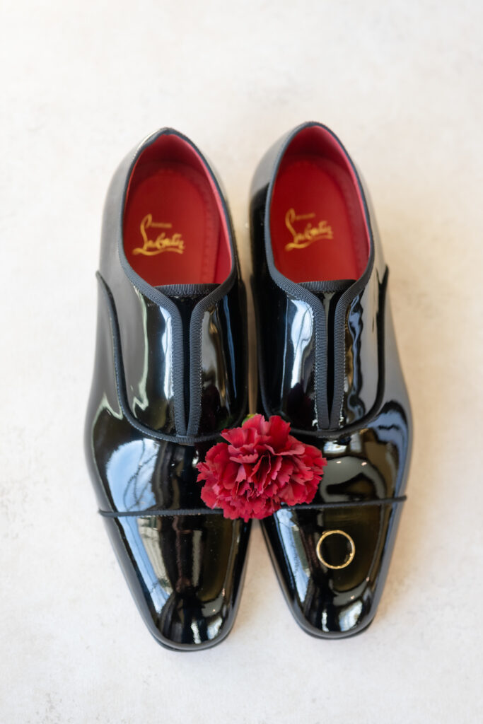Groom detail photo featuring black patent leather dress shoes and a wedding ring for a winter wedding at The Broadmoor in Colorado Springs