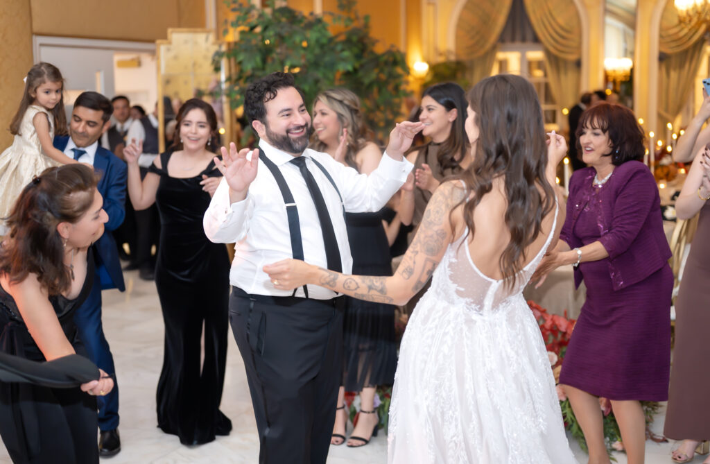 Bride and groom smiling and dancing with their friends and family, during their wedding reception, at The Broadmoor