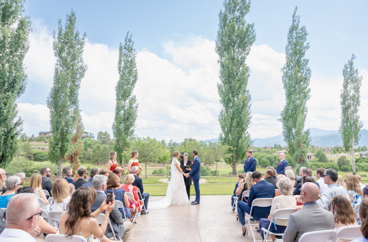 bride and groom exchanging vows during their colorado springs outdoor wedding at flying horse resort