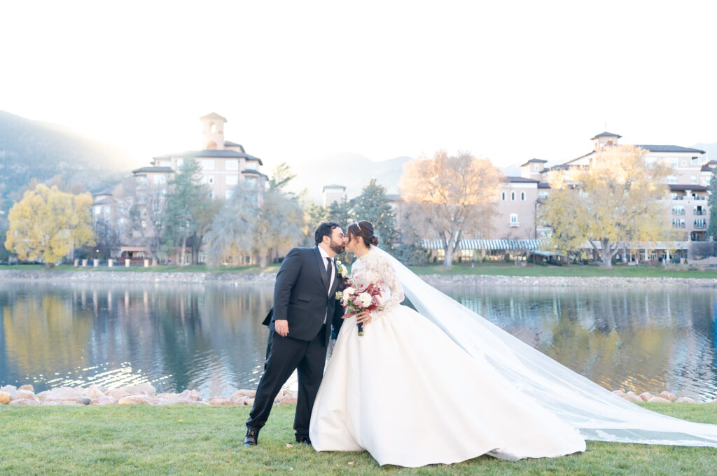Landscape photo of the bride and groom sharing a kiss, at The Broadmoor in Colorado Springs
