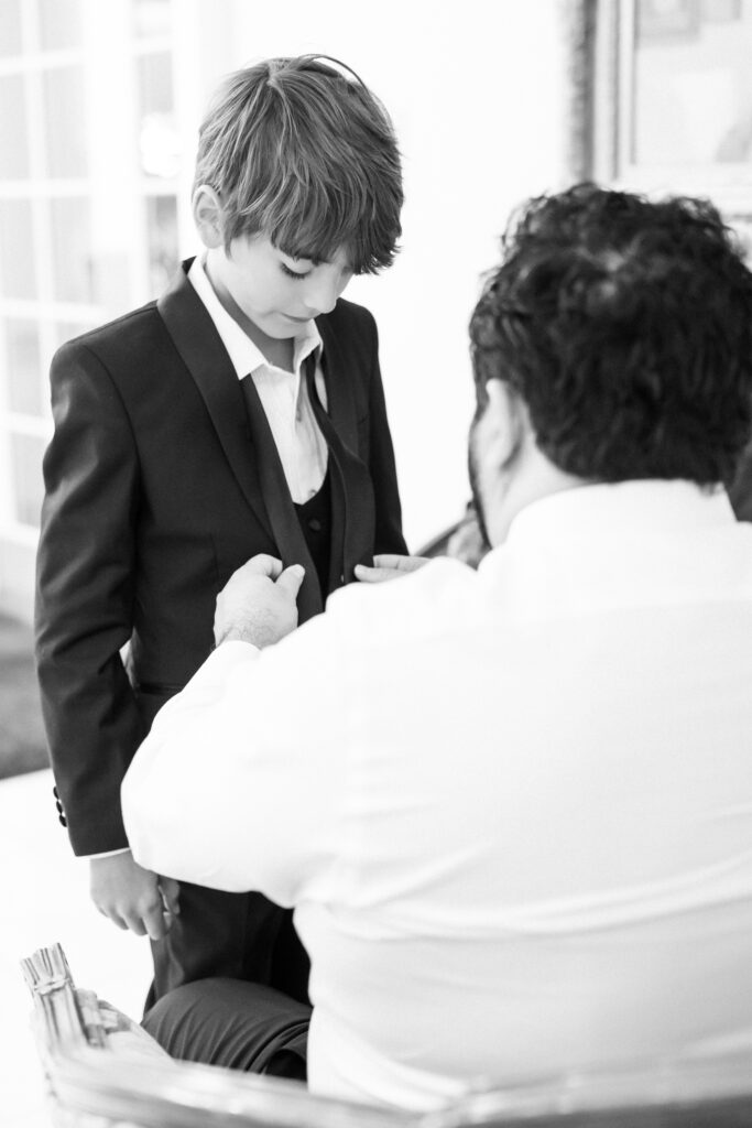 Groom helping his son with his tie on his colorado wedding day at The Broadmoor 