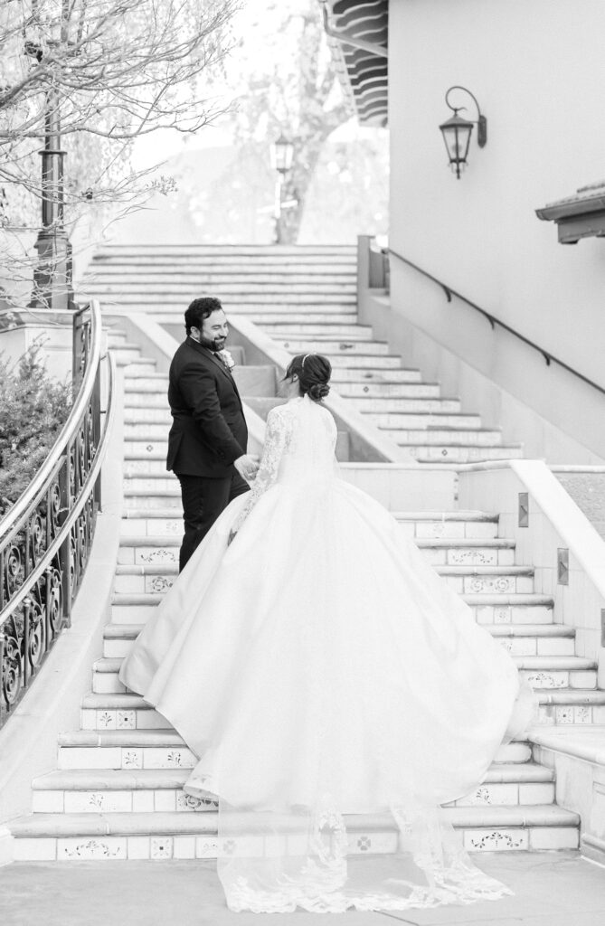 Groom leading his bride up the elegant staircase at The Broadmoor, for a romantic portrait on their Colorado Springs wedding day 