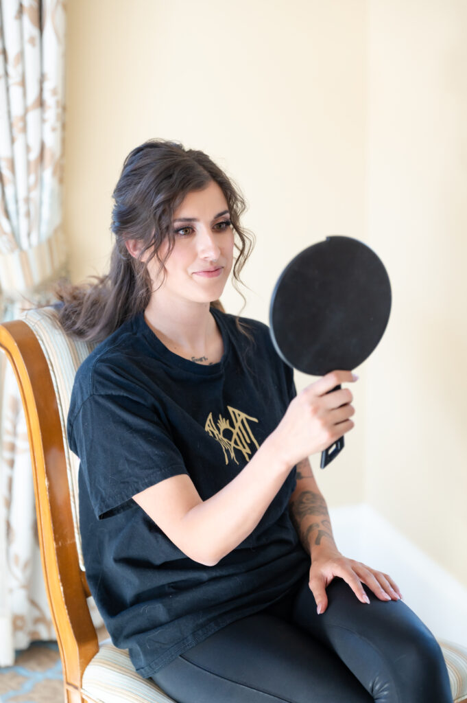 Bride looking in the mirror getting ready in her bridal suite at The Broadmoor, a Colorado Springs wedding venue