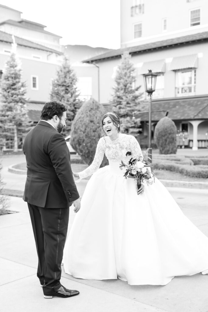 The bride and groom laughing and smiling together during their first look on their winter wedding day at The Broadmoor