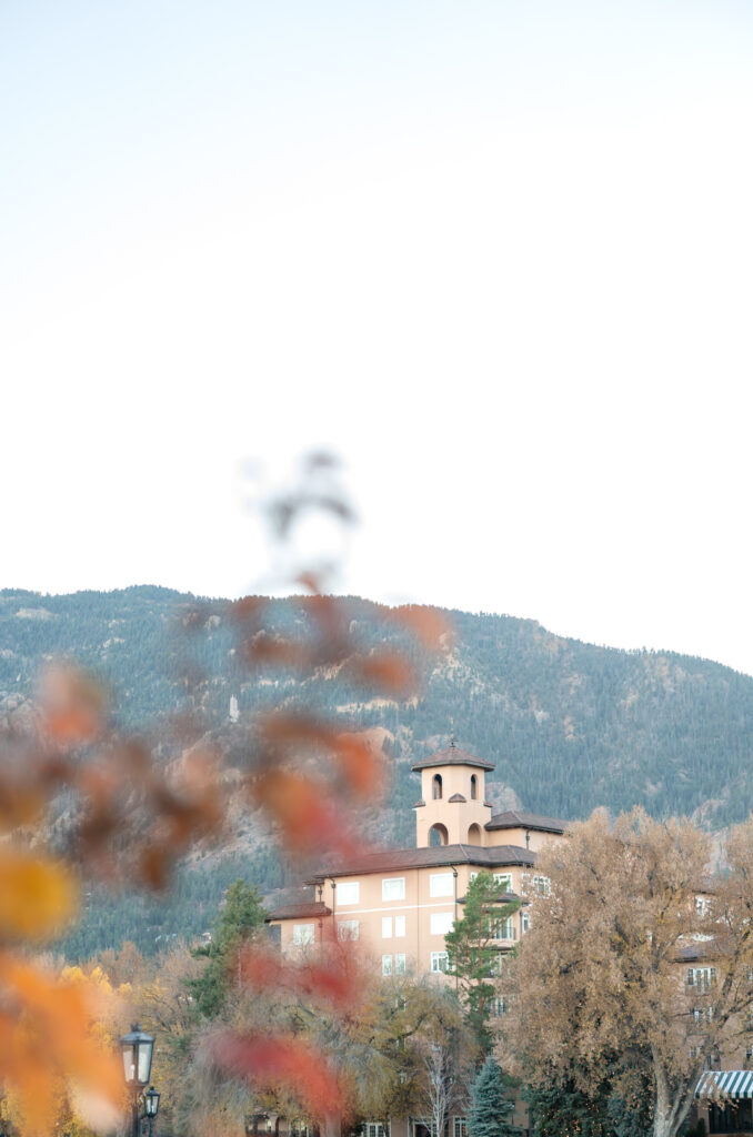 Detail photo of The Broadmoor building with fall foliage and mountain landscape 